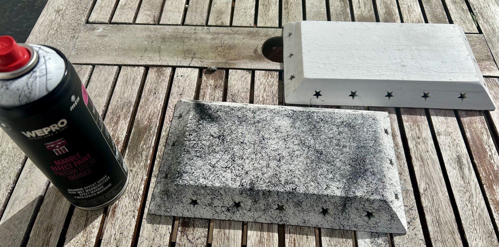 Prvá časť dekorácie s čiernym mramorovým efektom vedľa druhej, zatiaľ bielej